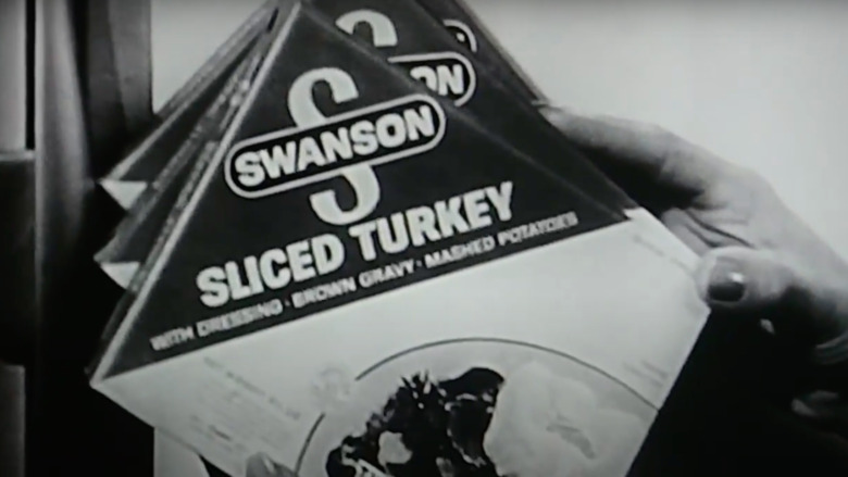 Hand holding Swanson's TV dinner in the '50s