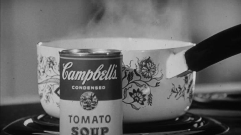 Pot of Campbell's soup on a stove with can in front