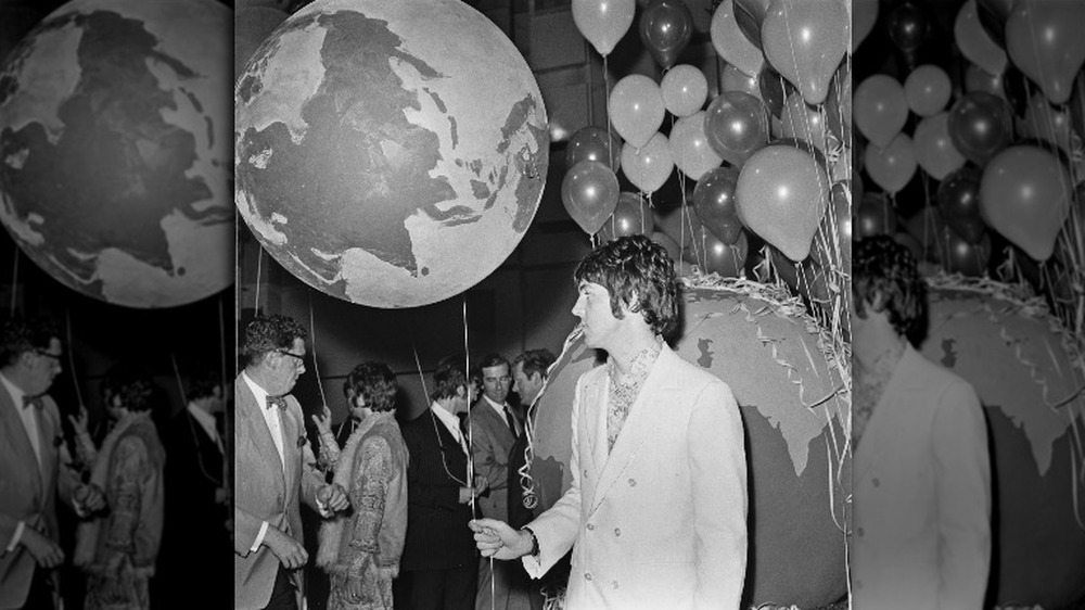 Paul McCartney holding a balloon of the Earth 