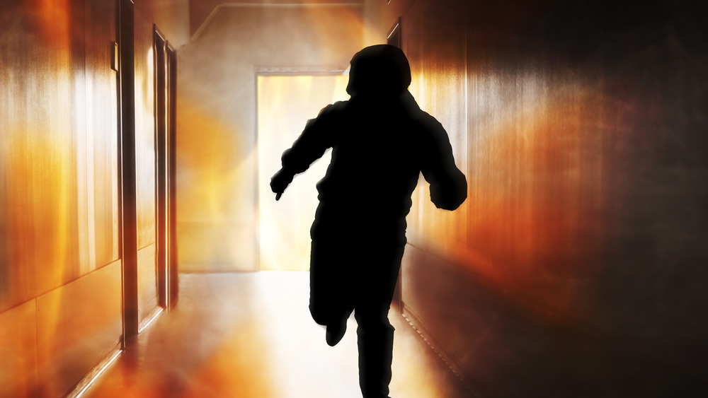 Silhouette of person running into fire