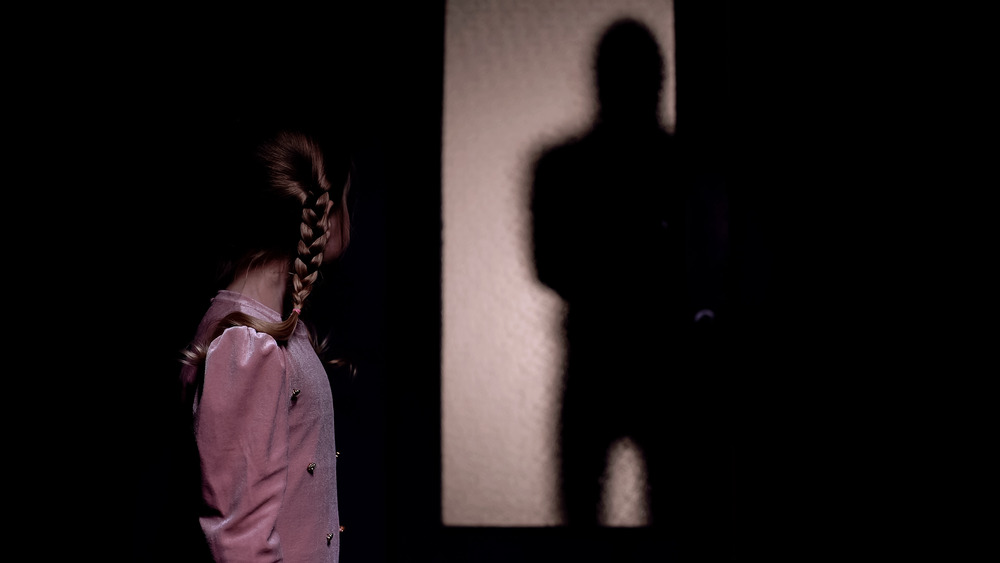 A young girl looking at a shadow