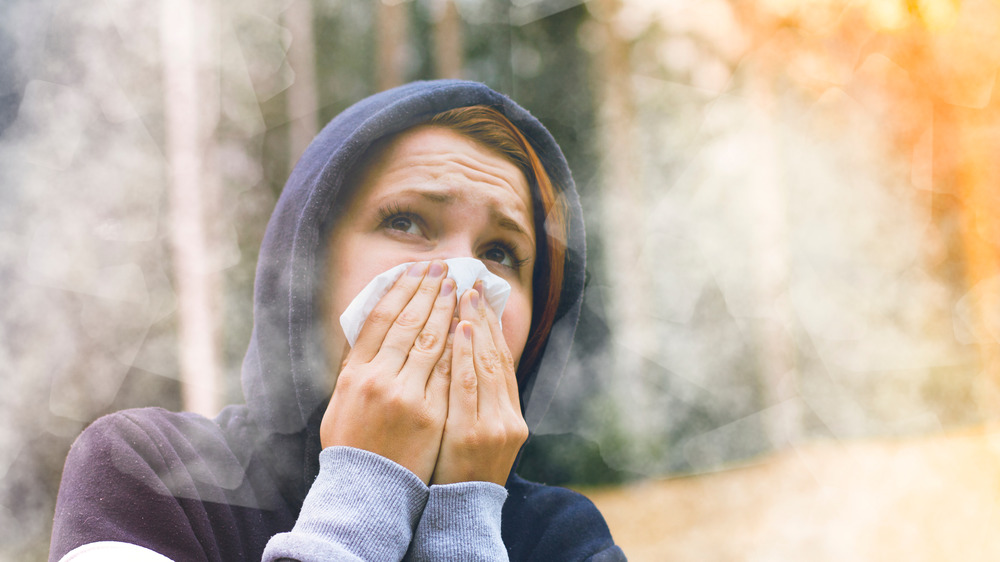 woman covering her mouth, surrounded by smoke