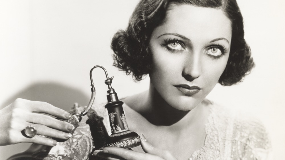A black and white picture of a woman holding an atomizer