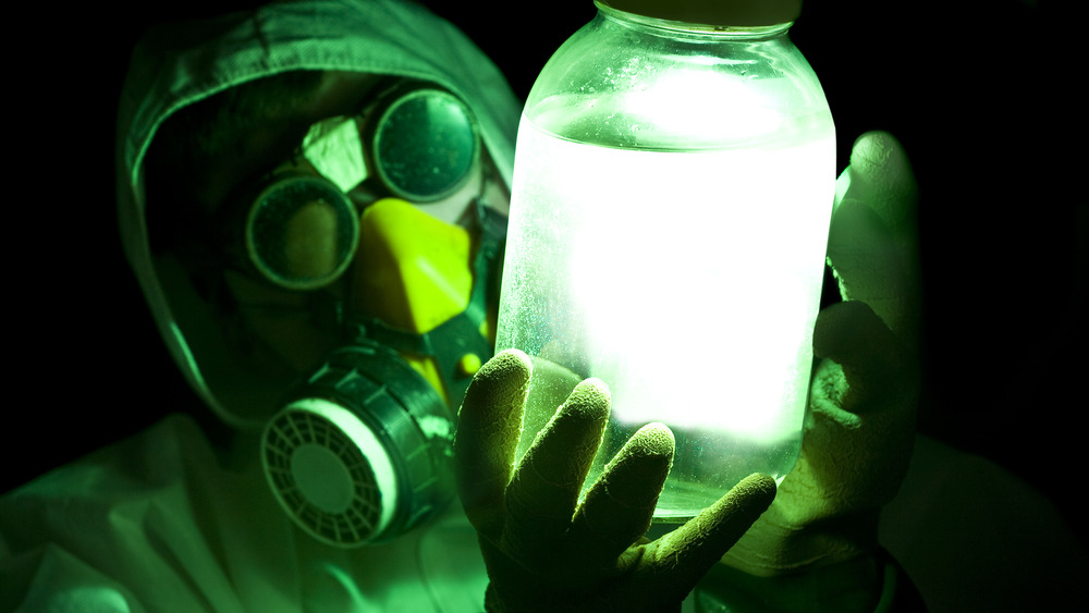 Man in gas mask, holding glowing jar