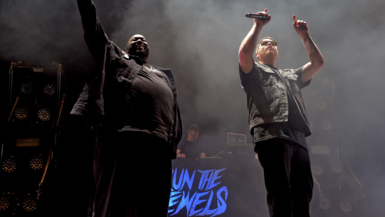Run the Jewels on stage with hands in the air