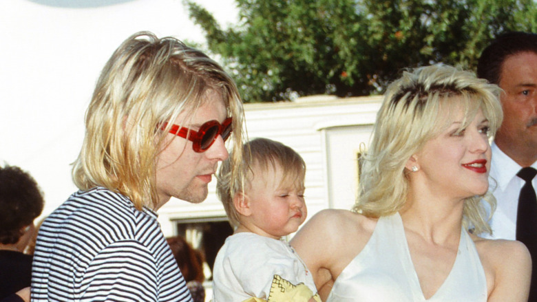 Kurt Cobain holding Frances Bean, next to Courtney Love