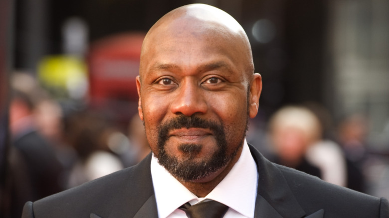 Lenny Henry in a suit smiling on the red carpet
