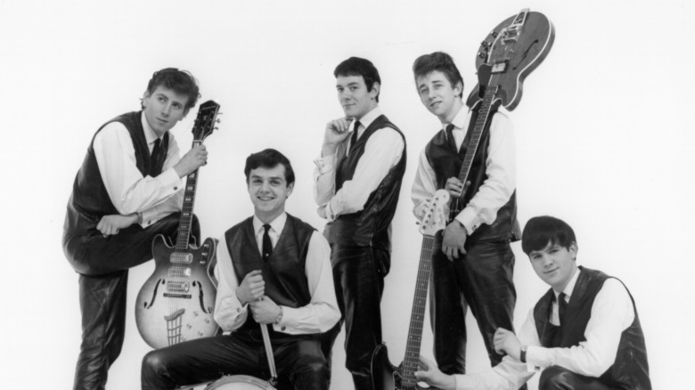 The Hollies standing holding instruments