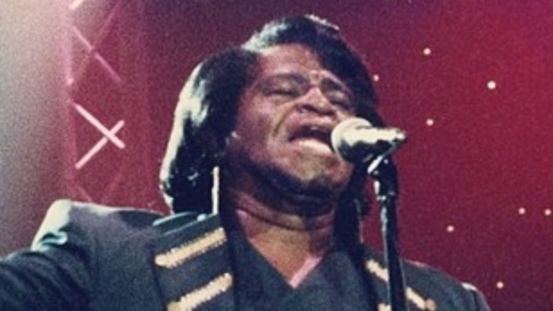 James Brown singing with hands raised
