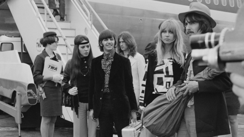 Ringo Starr with his wife Maureen Cox and George Harrison with his wife Pattie Boyd at Heathrow Airport right outside the stairs leading onto a plane