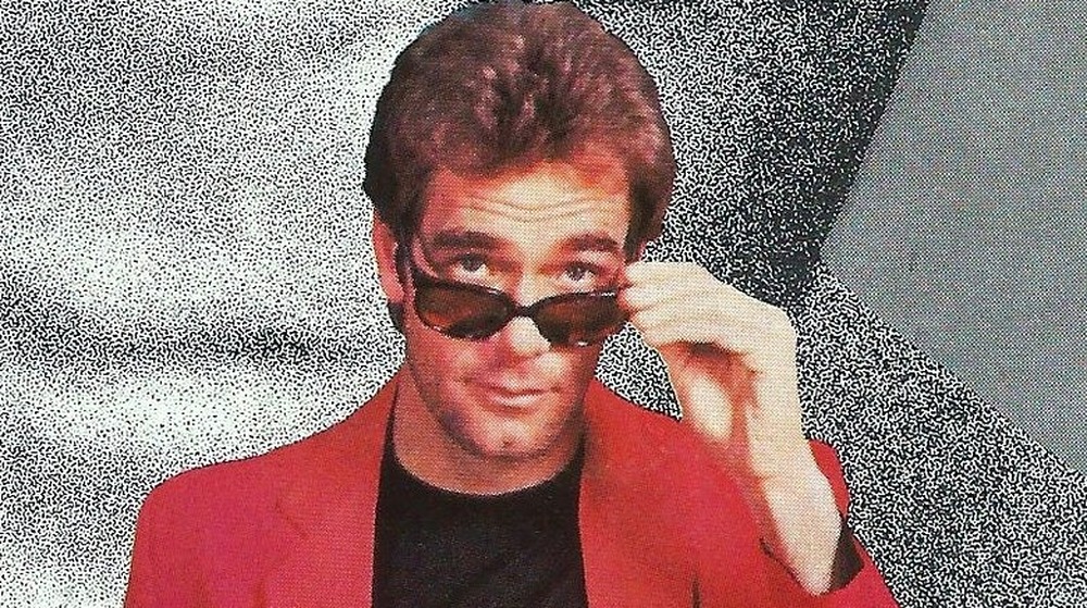 Huey Lewis holding sunglasses