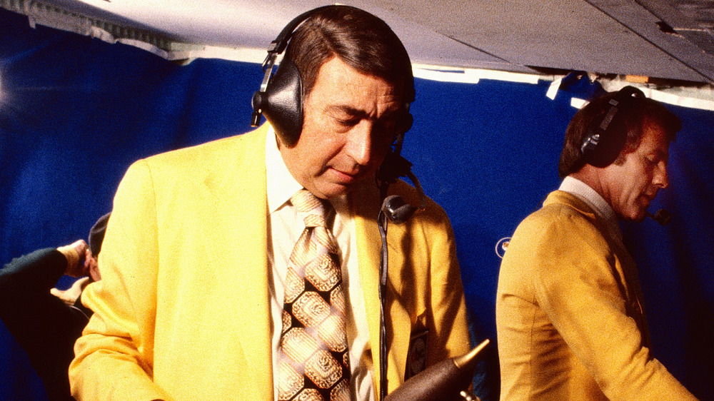 Howard Cosell wearing yellow jacket