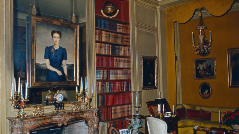 a portrait of Wallis Simpson hanging next to book shelves