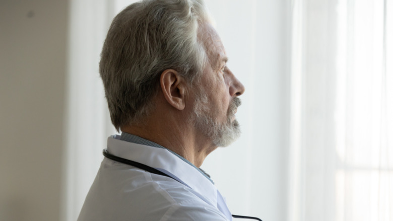 A male doctor looking out the window