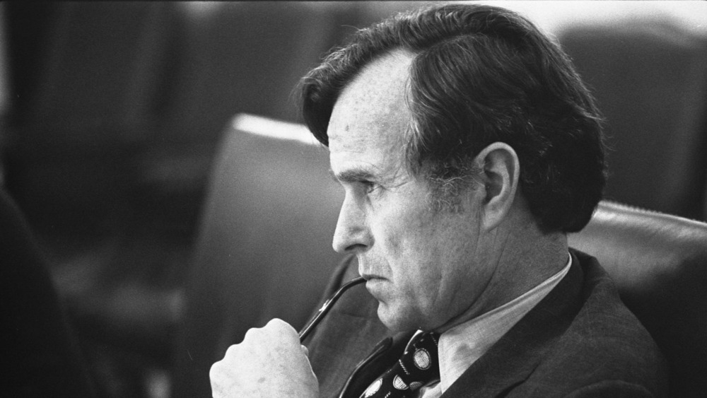 George H.W. Bush listens at a meeting 