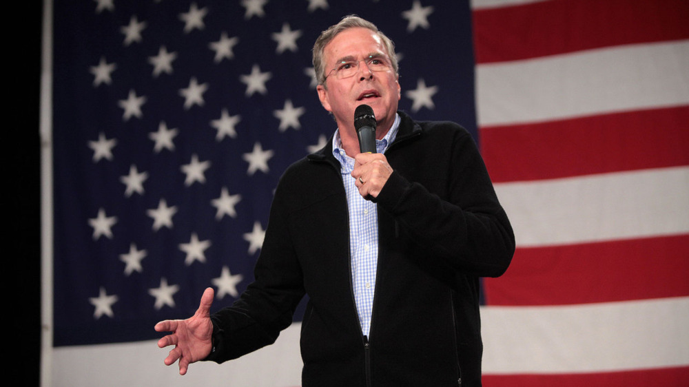 Jeb Bush speaking in front of flag