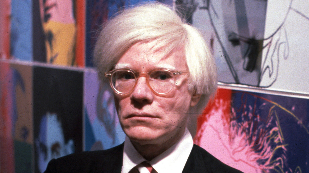 Andy Warhol with his art