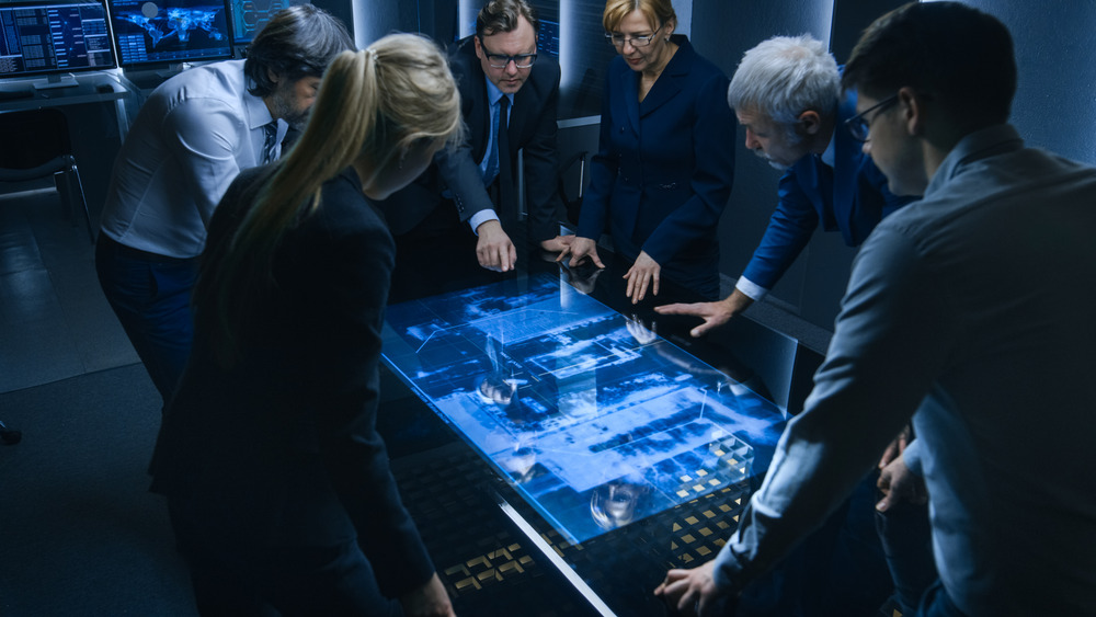 Agents Standing Around Digital Table 