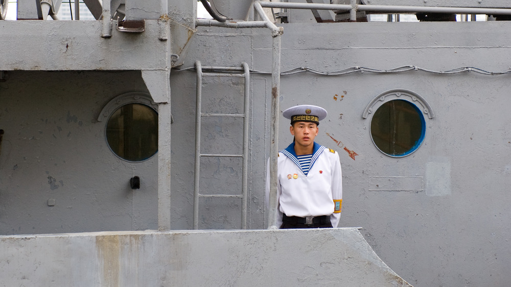 A North Korean sailor stands atop the USS Pueblo