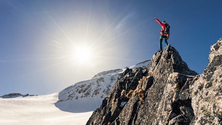 mountain climber celebrating on summit