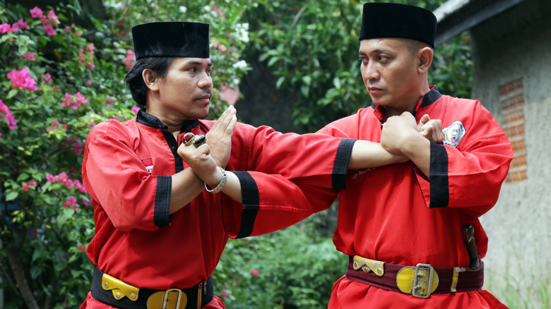 Pencak Silat fighters crossing arms