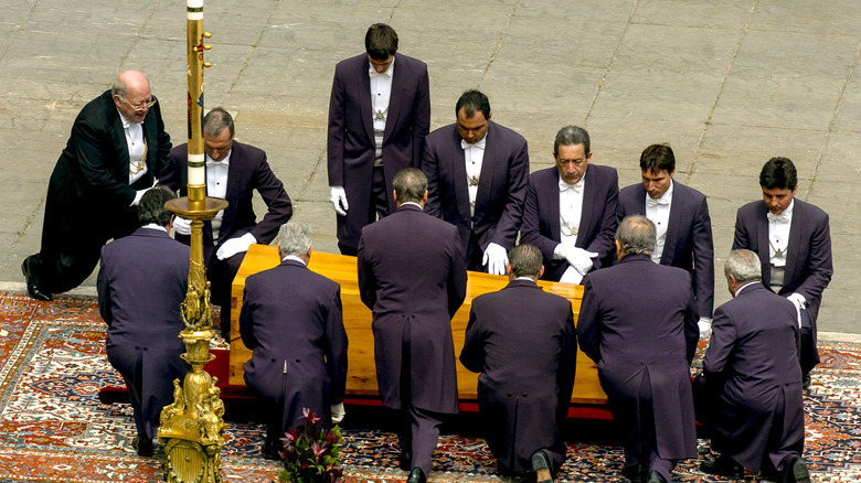 Pope funeral with footmen around coffin