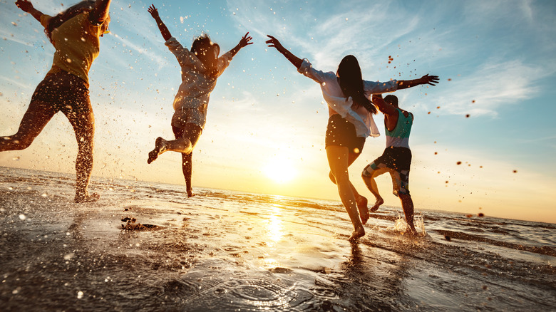 people jumping up and down on a beach