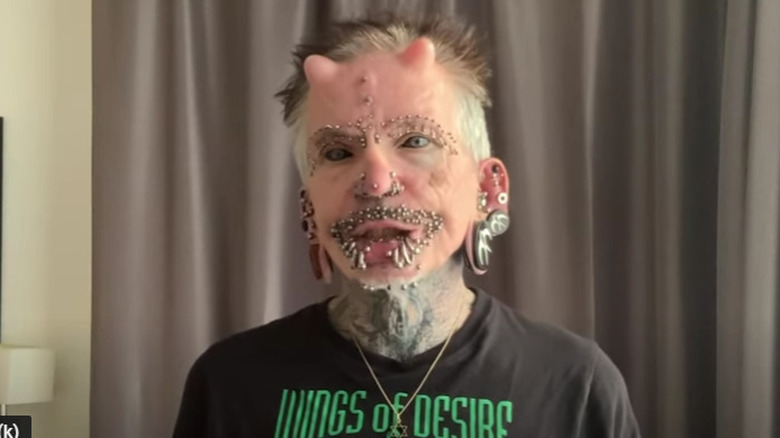 Man with many facial piercings