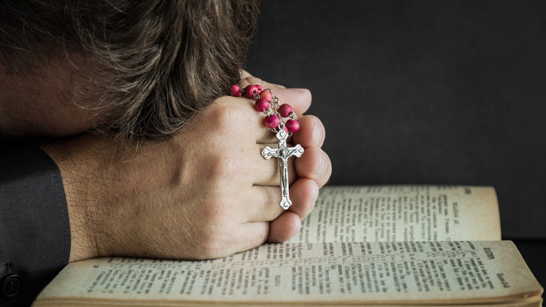 Priest crying into Bible