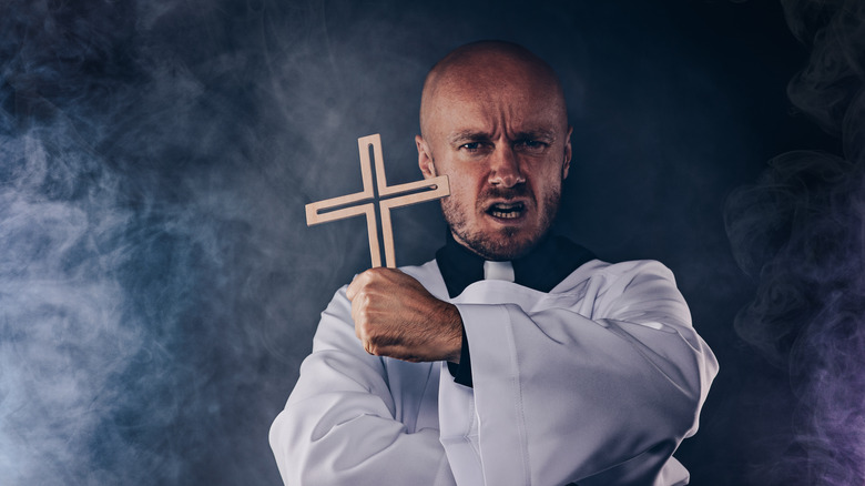 Catholic priest holding cross