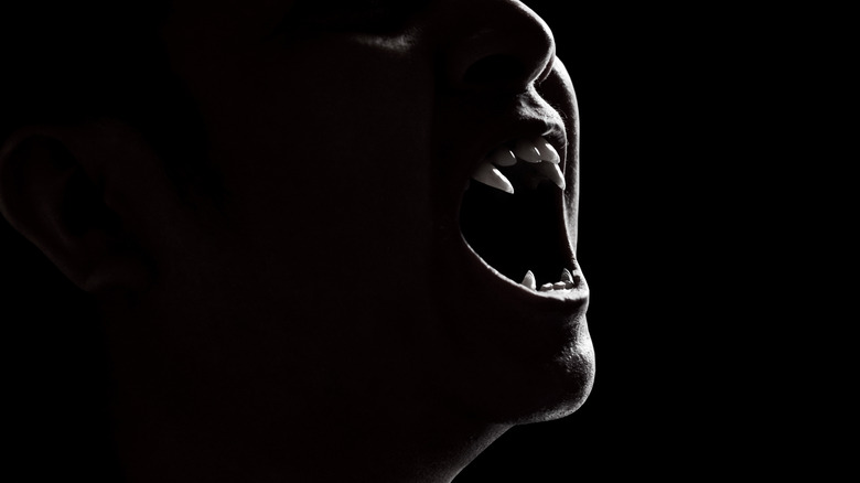 Vampire with mouth open on dark background