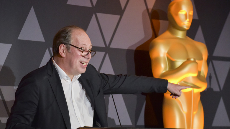 Hans Zimmer pointing towards Oscar statue
