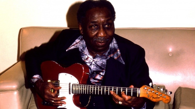 Muddy Waters backstage with electric guitar in the '70s.