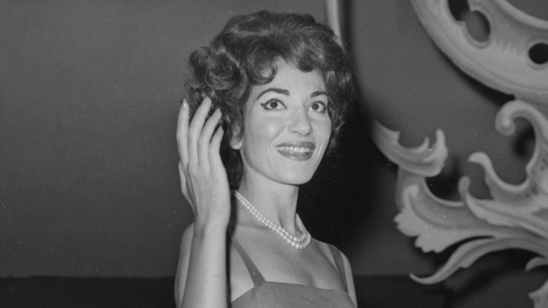 Maria callas waving in a ballroom gown