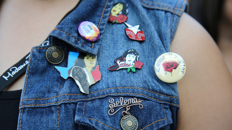 Close up of denim vest with Selena pins on it