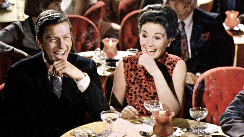 Dick Van Dyke smiling and sitting at table in Divorce American Style