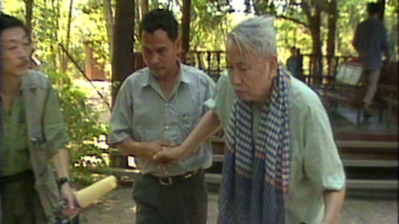 Cambodian dictator Pol Pot walking with help