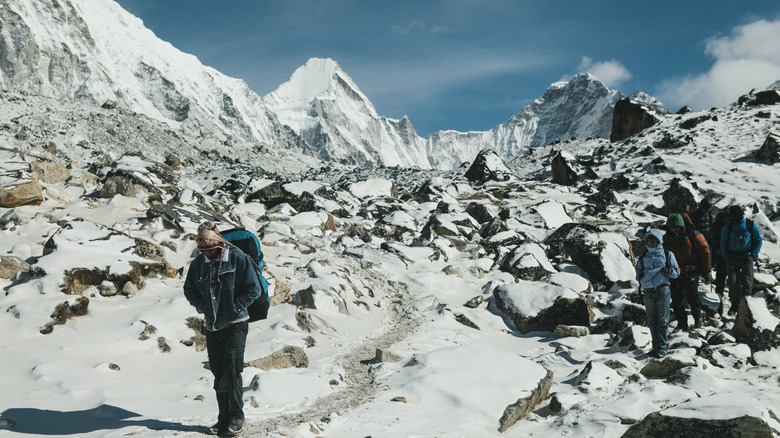 Mount Everest trekkers walking of snow-capped rocks