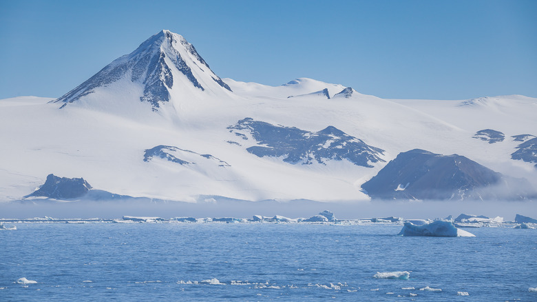 Antarctic peninsula with icebergs and blue water