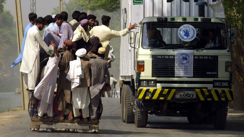 Refugees pass a food aid truck in Afghanistan 