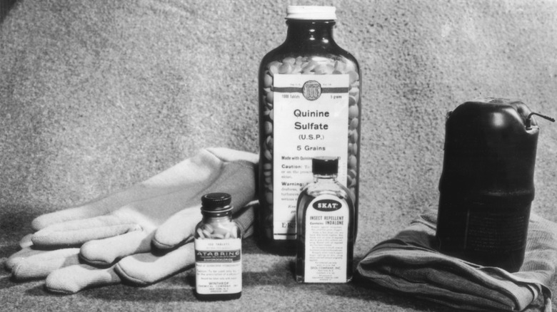 quinine bottle on table with gloves and other pill bottles