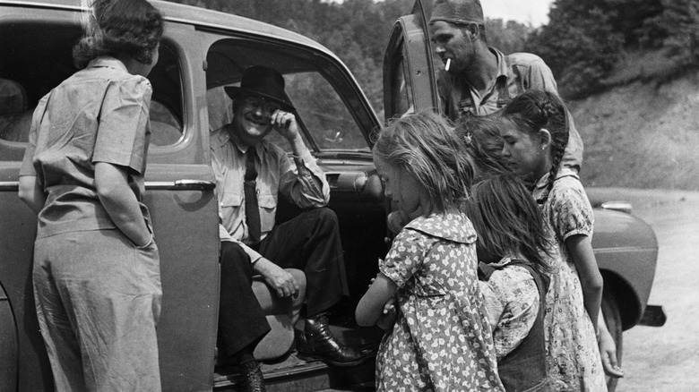 Children crowded around a car in 1937