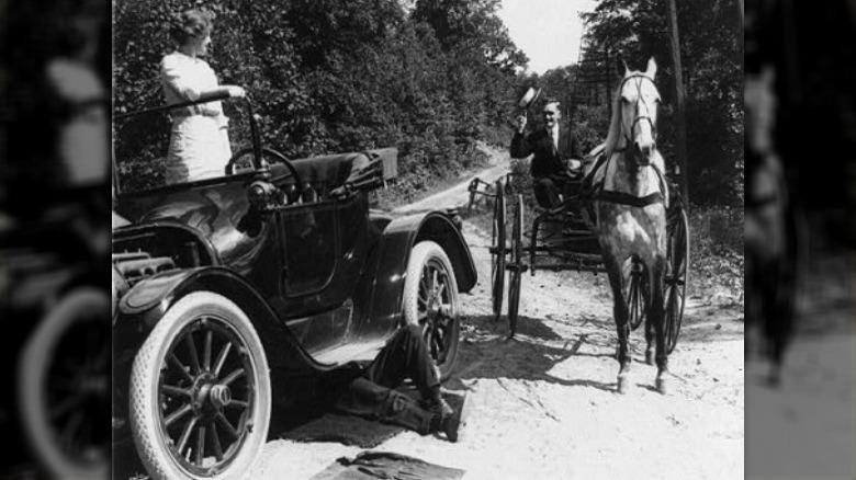 Woman stands on car