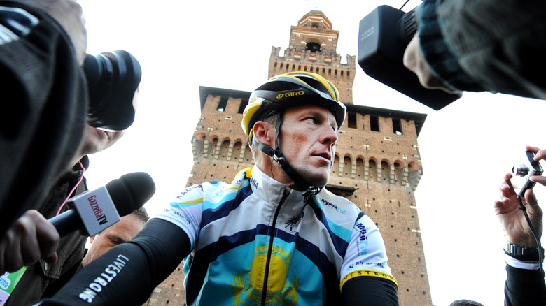 Lance Armstrong surrounded by reporters