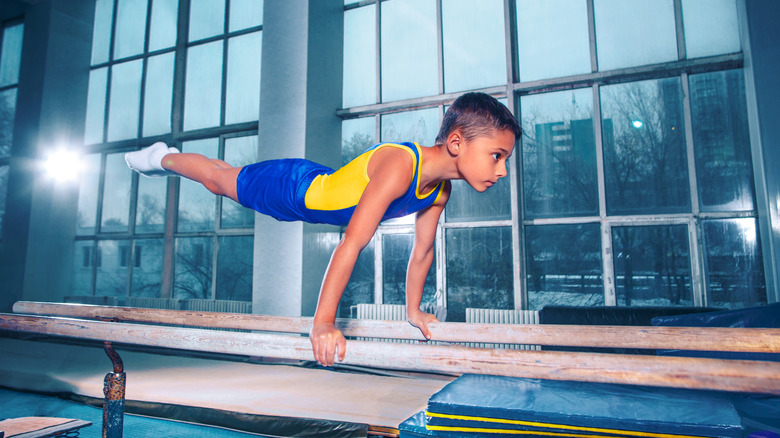 boy practicing parallel bars