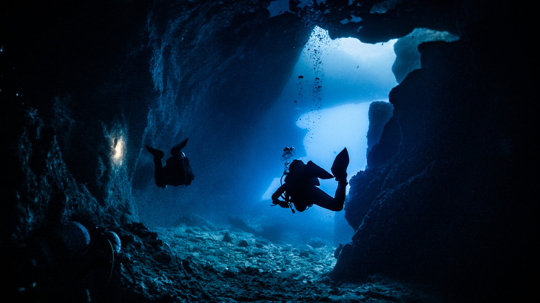 Underwater divers in a cave