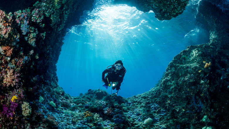 Underwater diver between rocks