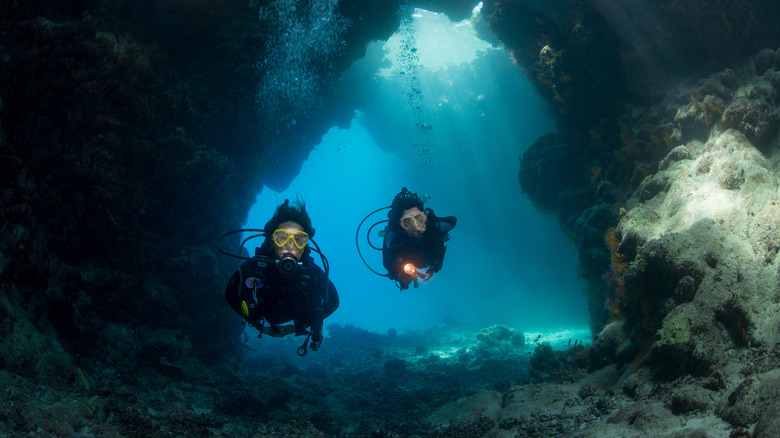 Two underwater divers in cave