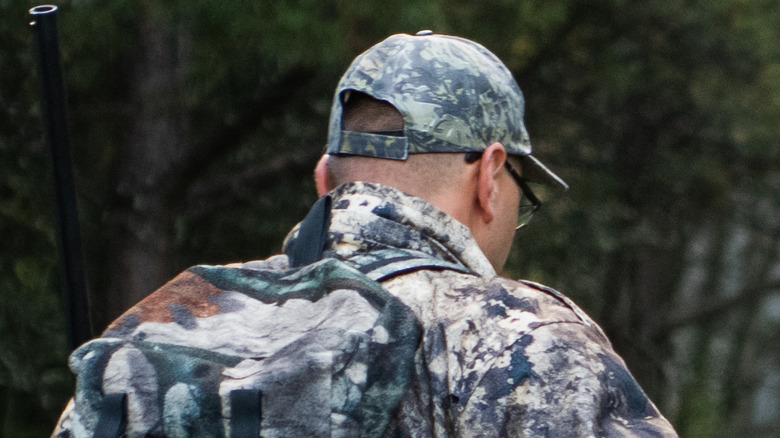 A hunter and his son walking in the woods