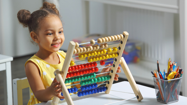 girl using counting toy 